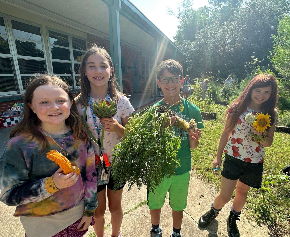 students with garden flowers and vegetables